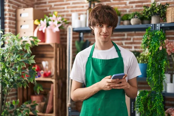 Jonge Blonde Man Bloemist Glimlachen Zelfverzekerd Met Behulp Van Smartphone — Stockfoto