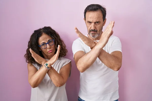 Middelbare Leeftijd Hispanic Paar Samen Roze Achtergrond Afwijzing Expressie Kruising — Stockfoto