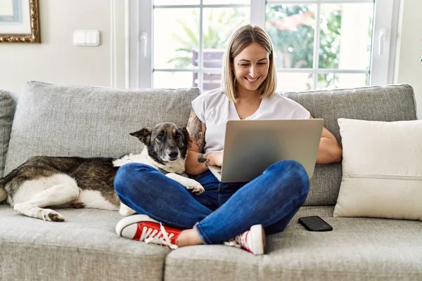Jovem Caucasiana Sorrindo Feliz Sentado Sofá Com Cão Usando Laptop — Fotografia de Stock