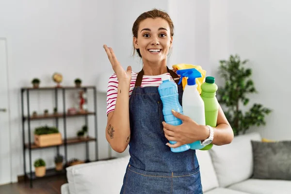 Young Brunette Woman Wearing Apron Holding Cleaning Products Celebrating Victory — Stock Photo, Image