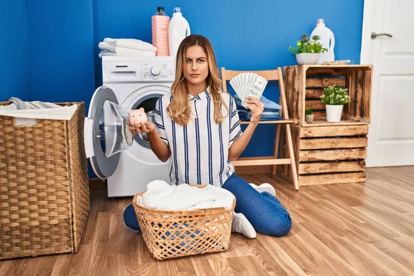 Young Blonde Woman Doing Laundry Saving Money Skeptic Nervous Frowning — Stockfoto