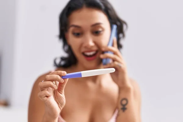 Young Beautiful Hispanic Woman Talking Smartphone Holding Pregnancy Test Bedroom — Stock Photo, Image