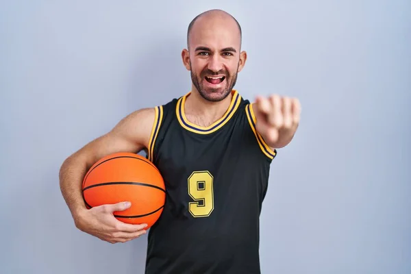 Pemuda Botak Dengan Jenggot Mengenakan Seragam Basket Memegang Bola Menunjuk — Stok Foto
