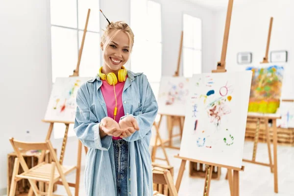 Young caucasian girl at art studio smiling with hands palms together receiving or giving gesture. hold and protection