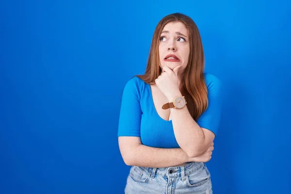 Rossa Donna Piedi Sopra Sfondo Blu Pensando Preoccupato Una Domanda — Foto Stock