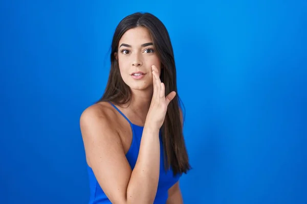 Hispanic Woman Standing Blue Background Hand Mouth Telling Secret Rumor — стокове фото