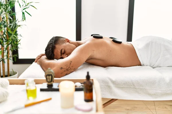 Young Hispanic Man Relaxed Having Back Massage Using Black Stones — Stockfoto