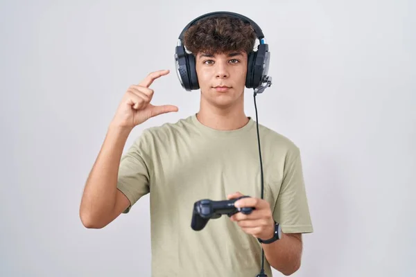 Adolescente Hispânico Jogando Vídeo Game Segurando Controlador Sorrindo Gestos Confiantes — Fotografia de Stock