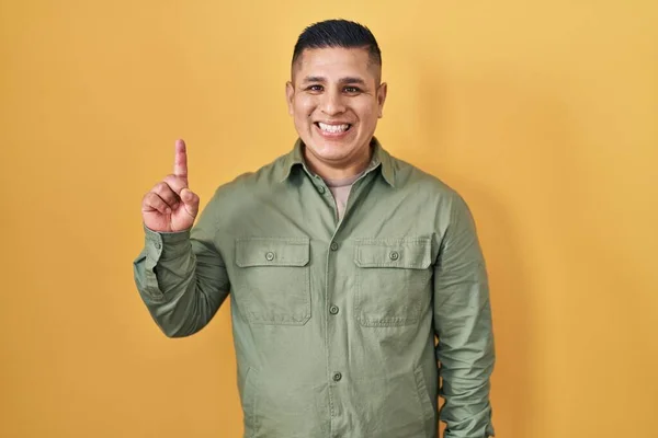 Joven Hispano Pie Sobre Fondo Amarillo Mostrando Señalando Con Dedo —  Fotos de Stock