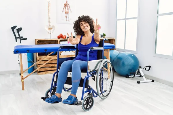 Fizyoterapi Kliniğinde Tekerlekli Sandalyede Oturan Genç Orta Doğulu Kadın Kameraya — Stok fotoğraf