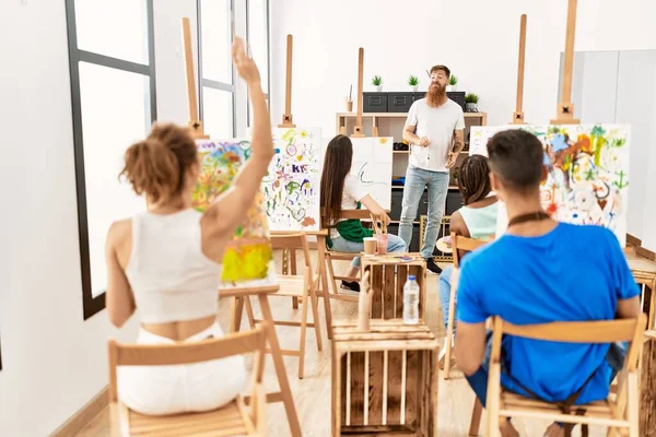 Group of people smiling happy drawing in paint class at art studio.