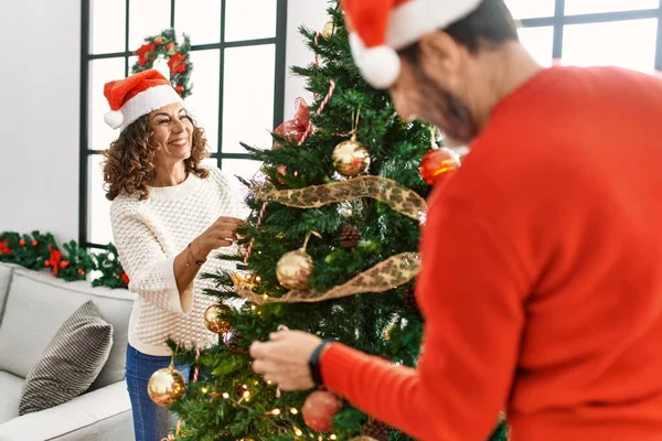 Orta Yaşlı Spanyol Çift Gülümsüyor Mutlu Noel Ağacı Süslüyor Evde — Stok fotoğraf