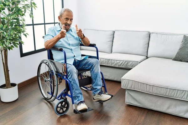 Ein Gutaussehender Älterer Herr Sitzt Rollstuhl Wohnzimmer Und Zeigt Mit — Stockfoto