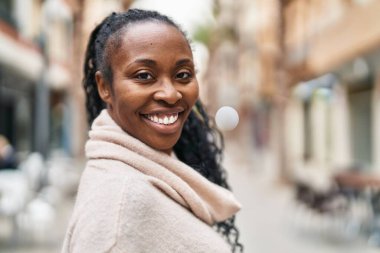 Sokakta kendine güvenen Afrikalı Amerikalı kadın gülümsüyor