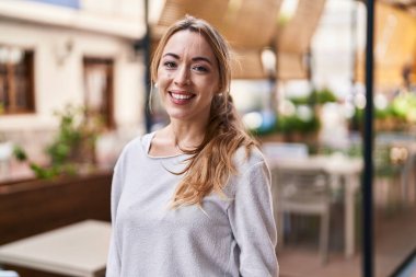 Sokakta kendinden emin gülümseyen genç bir kadın