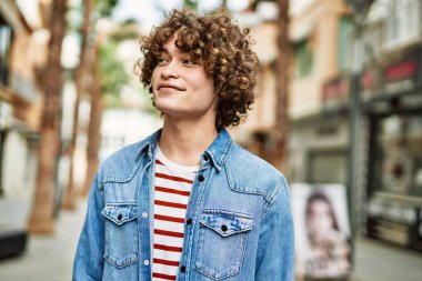 Genç İspanyol adam şehre gülümsüyor.