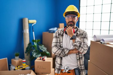 Evde çalışan sakallı genç İspanyol bir adam bir soru hakkında endişeli ve gergin bir şekilde düşünüyor. 