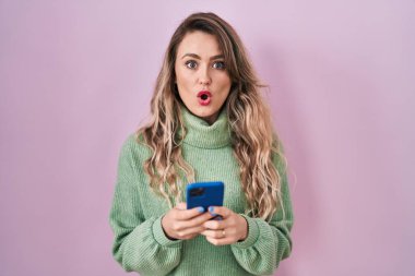 Kafkasyalı genç bir kadın akıllı telefon kullanıyor. Mesaj yazıyor. Korkmuş ve şok olmuş bir halde.. 