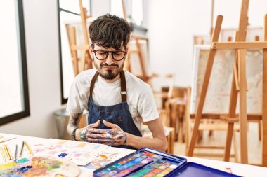 Sanat stüdyosunda sakallı, midesi bulanan İspanyol bir adam. Çünkü mide bulantısı ve acı veren bir hastalık var. Ağrı kavramı. 