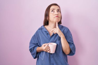 Orta yaşlı Latin bir kadın kahve içerken şüphe üzerine yoğunlaşmıştı. Parmakları çenesinde ve yukarı bakıyordu. 