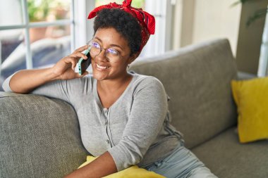 Afro-amerikan kadın akıllı telefonuyla konuşuyor.