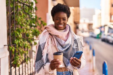 Sokakta kahve içen Afro-Amerikan kadın.
