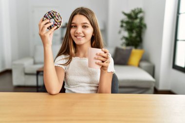 Çok tatlı bir kız kahvaltısını evde, masada yapıyor.