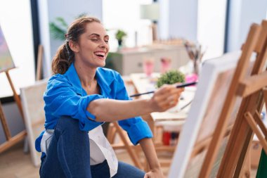Young woman artist smiling confident drawing at art studio