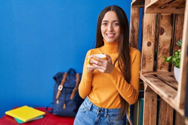 Genç ve güzel İspanyol kadın evde kahve içiyor.