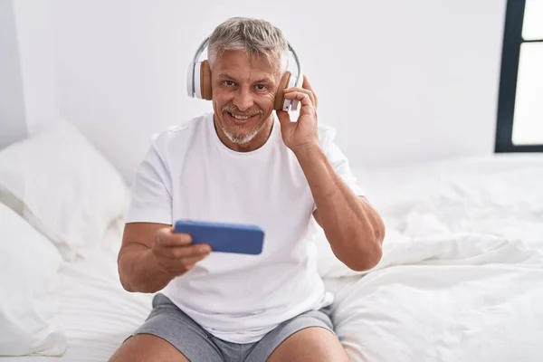 Middelbare Leeftijd Grijsharige Man Luisteren Naar Muziek Zitten Bed Slaapkamer — Stockfoto