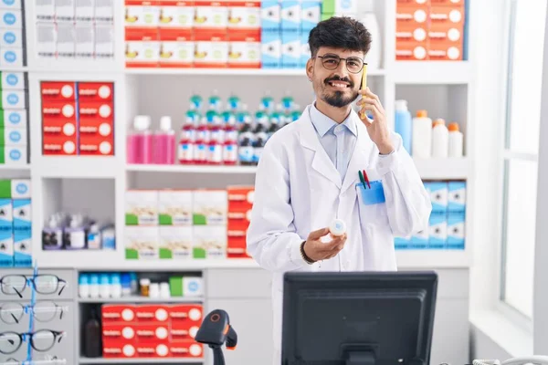 Jovem Homem Hispânico Farmacêutico Falando Smartphone Segurando Pílulas Farmácia — Fotografia de Stock
