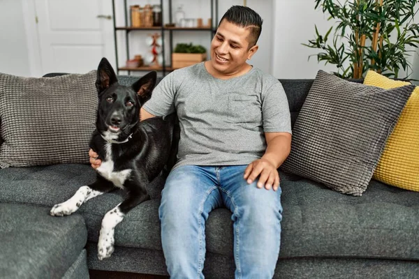 Jovem Hispânico Sorrindo Feliz Sentado Sofá Com Cão Casa — Fotografia de Stock