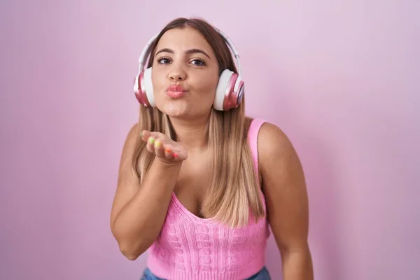 Mujer Rubia Joven Escuchando Música Usando Auriculares Mirando Cámara Soplando — Foto de Stock