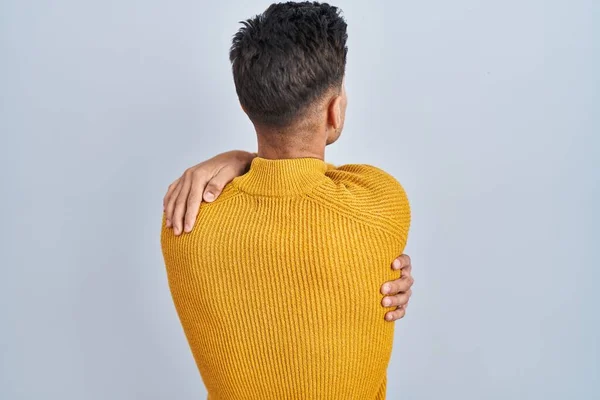 Νεαρός Ισπανός Που Στέκεται Πάνω Από Μπλε Φόντο Αγκαλιάζοντας Τον — Φωτογραφία Αρχείου