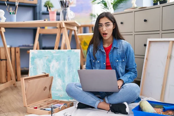 Young Teenager Girl Sitting Art Studio Using Laptop Scared Amazed — Stockfoto