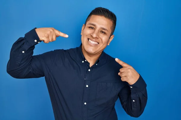 Латиноамериканец Стоит Синем Фоне Весело Улыбаясь Показывая Пальцами Зубы Рот — стоковое фото