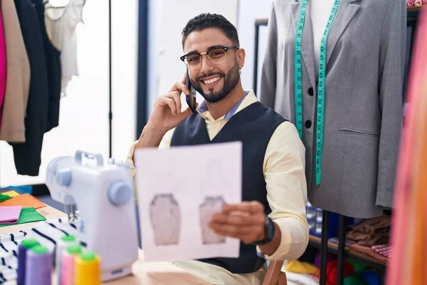 服装厂年轻的阿拉伯男子裁缝师谈智能手机服装设计 — 图库照片