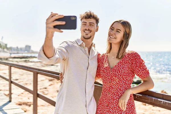 남녀가 휴가중에 웃으며 행복하게 해변에서 스마트폰으로 셀카를 만들고 있습니다 — 스톡 사진