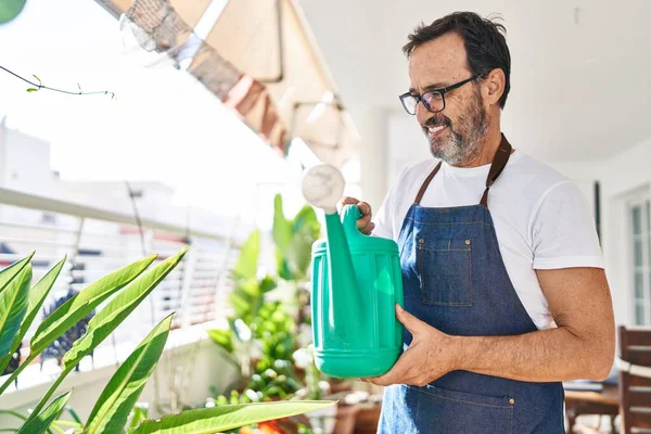 Middelbare Leeftijd Man Glimlachend Zelfverzekerde Besproeiende Planten Terras Thuis — Stockfoto