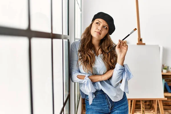 Joven Mujer Hispana Hermosa Artista Sosteniendo Pincel Apoyado Pared Estudio — Foto de Stock