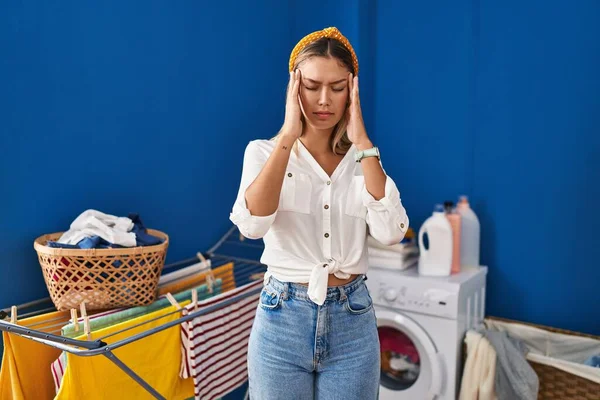 頭の上に手で洗濯室で若いブロンドの女性 頭痛の種ので ストレス 片頭痛 — ストック写真