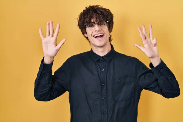 Młody Człowiek Okularach Żółtym Tle Pokazuje Wskazuje Palcami Numer Dziewięć — Zdjęcie stockowe