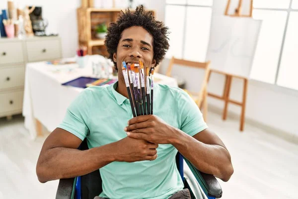 若いアフリカ系アメリカ人障害者の画家で 車椅子に腰掛けて絵筆を持っている — ストック写真