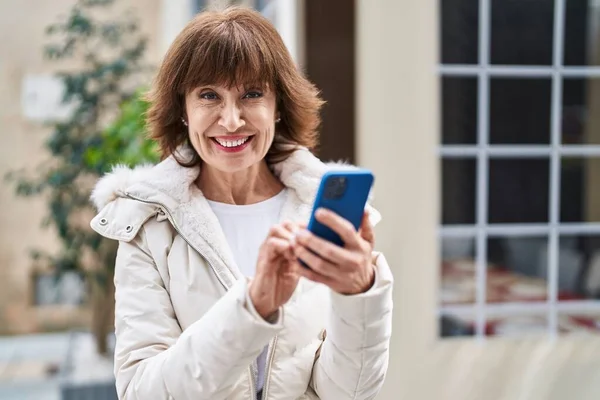 Mujer Mediana Edad Sonriendo Confiada Usando Teléfono Inteligente Terraza Cafetería —  Fotos de Stock