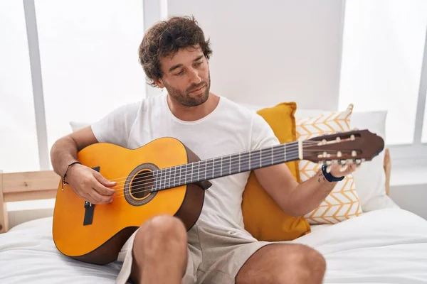 Ung Latinamerikansk Man Spelar Klassisk Gitarr Sittandes Sängen Sovrummet — Stockfoto