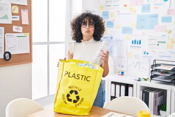 事務所でプラスチックボトルでリサイクルバッグを保持している若い中東の女性は落ち込んでおり 苦痛を心配し 怒って恐れて泣いています 悲しい表情 — ストック写真