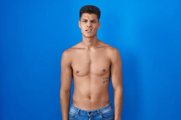 Joven Hombre Hispano Pie Sin Camisa Sobre Fondo Azul Buscando —  Fotos de Stock