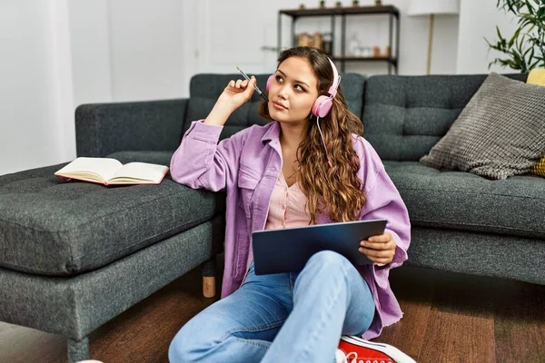 Genç ve güzel İspanyol kadın evde oturmuş müzik dinliyor.