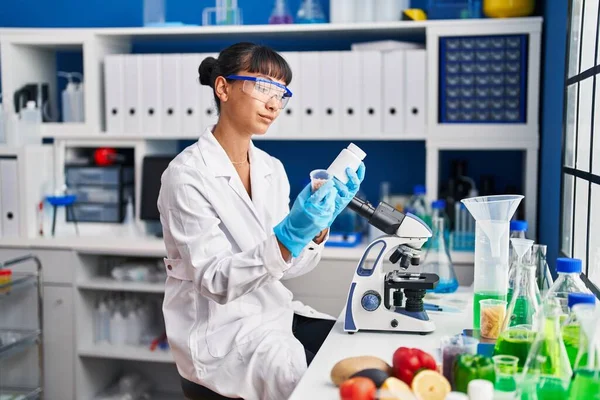 年轻美丽的惊慌失措的女科学家在实验室拿着药瓶 — 图库照片