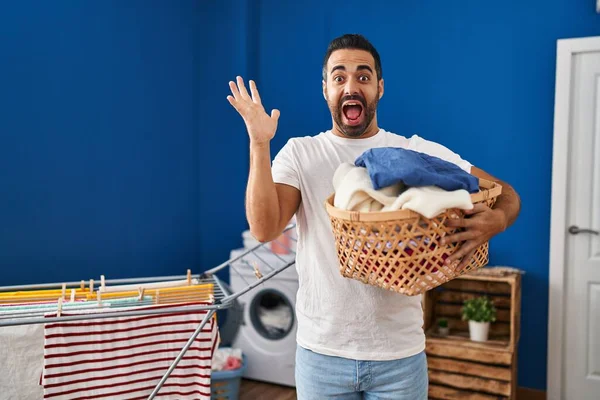 Joven Hombre Hispano Con Barba Sosteniendo Cesta Lavandería Celebrando Victoria — Foto de Stock